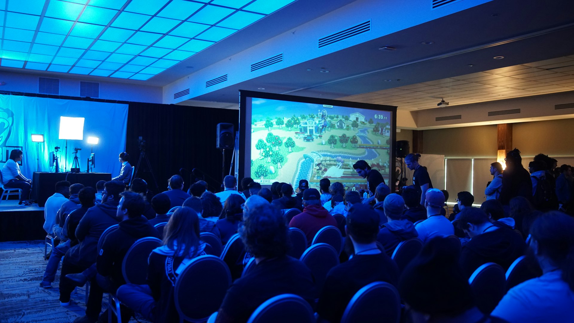 Players at neon-lit battle stations inside Titan Treasure Protocol gaming arena